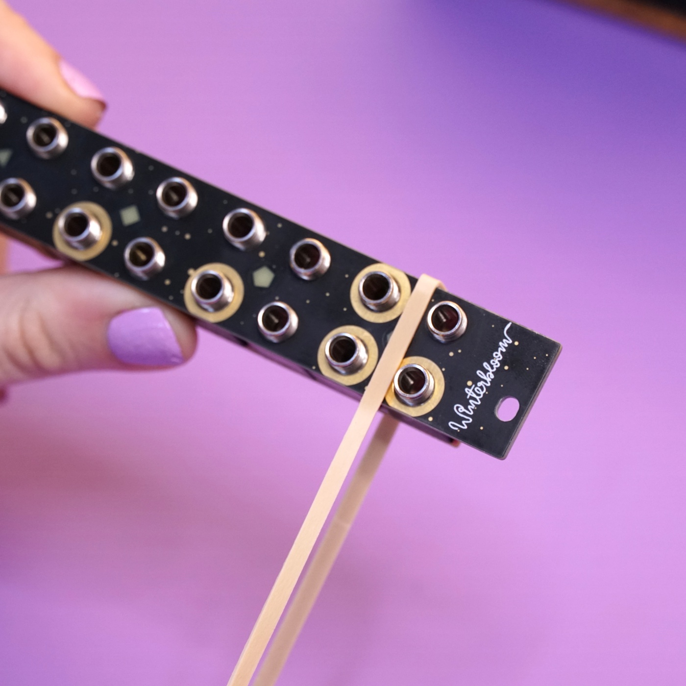 A rubber band being pulled taught over one side of the module